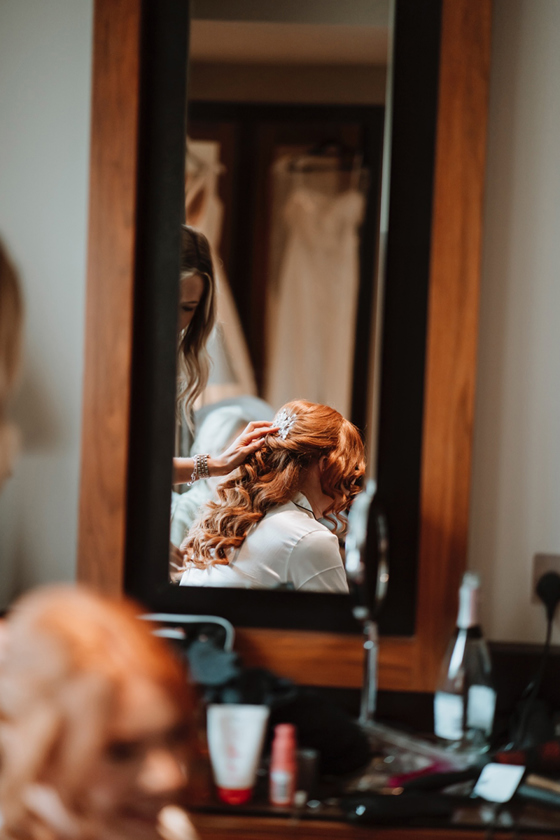 Mirror shot of brides curled red hair